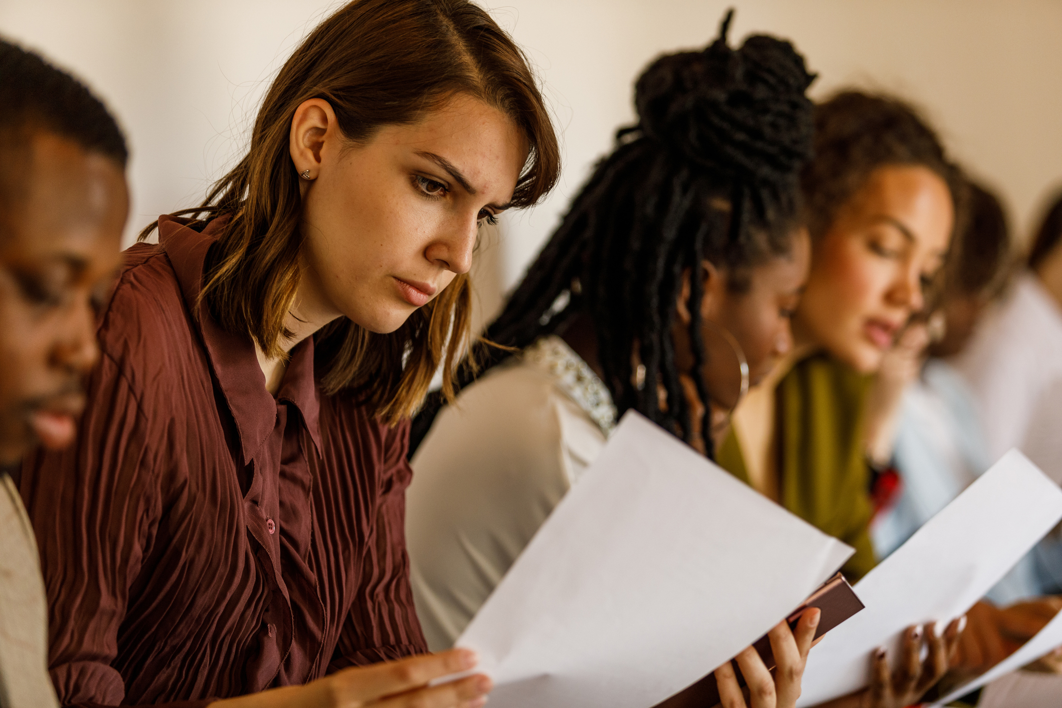 A woman with a serious face looking at documents